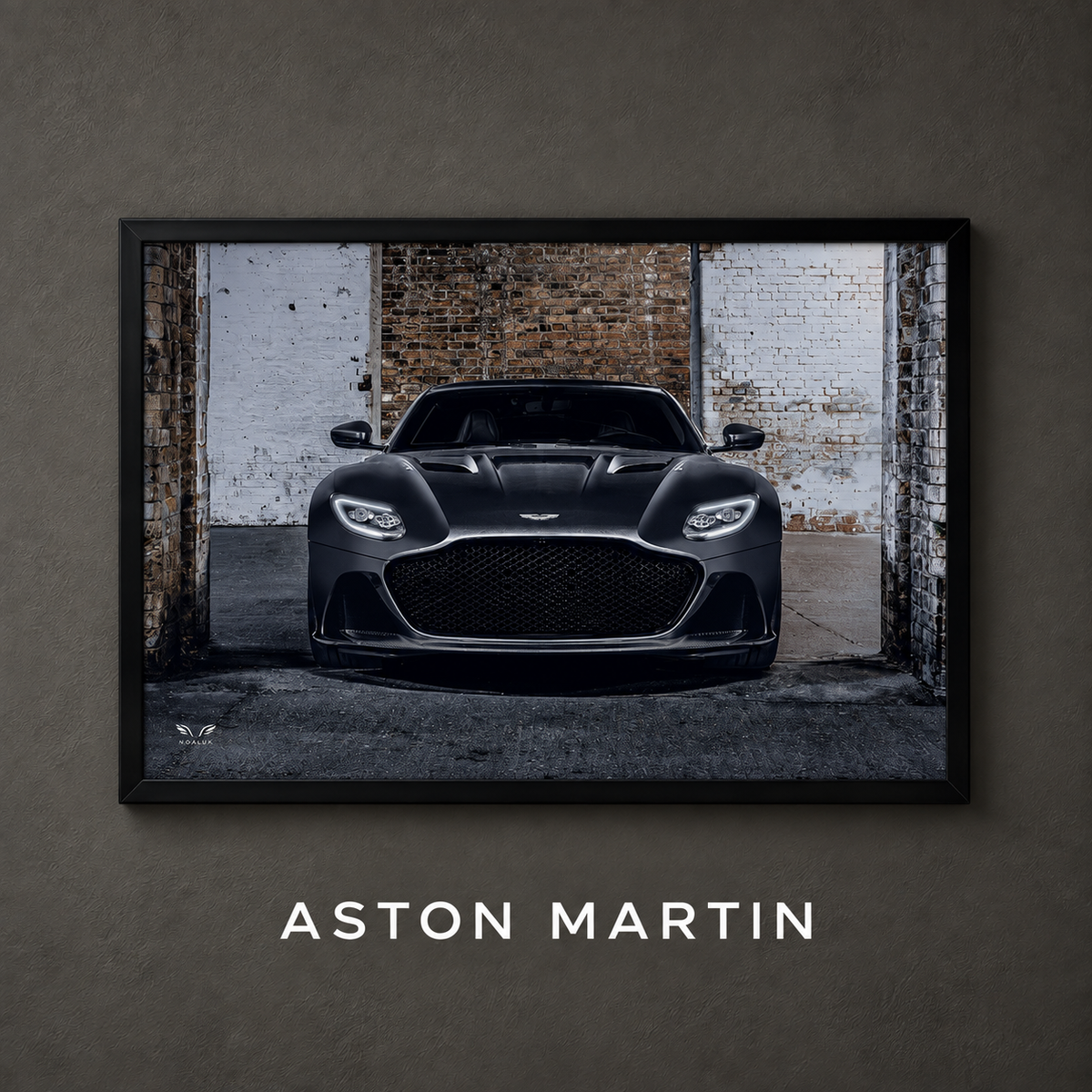 Framed Aston Martin car poster on a charcoal wall with collection label