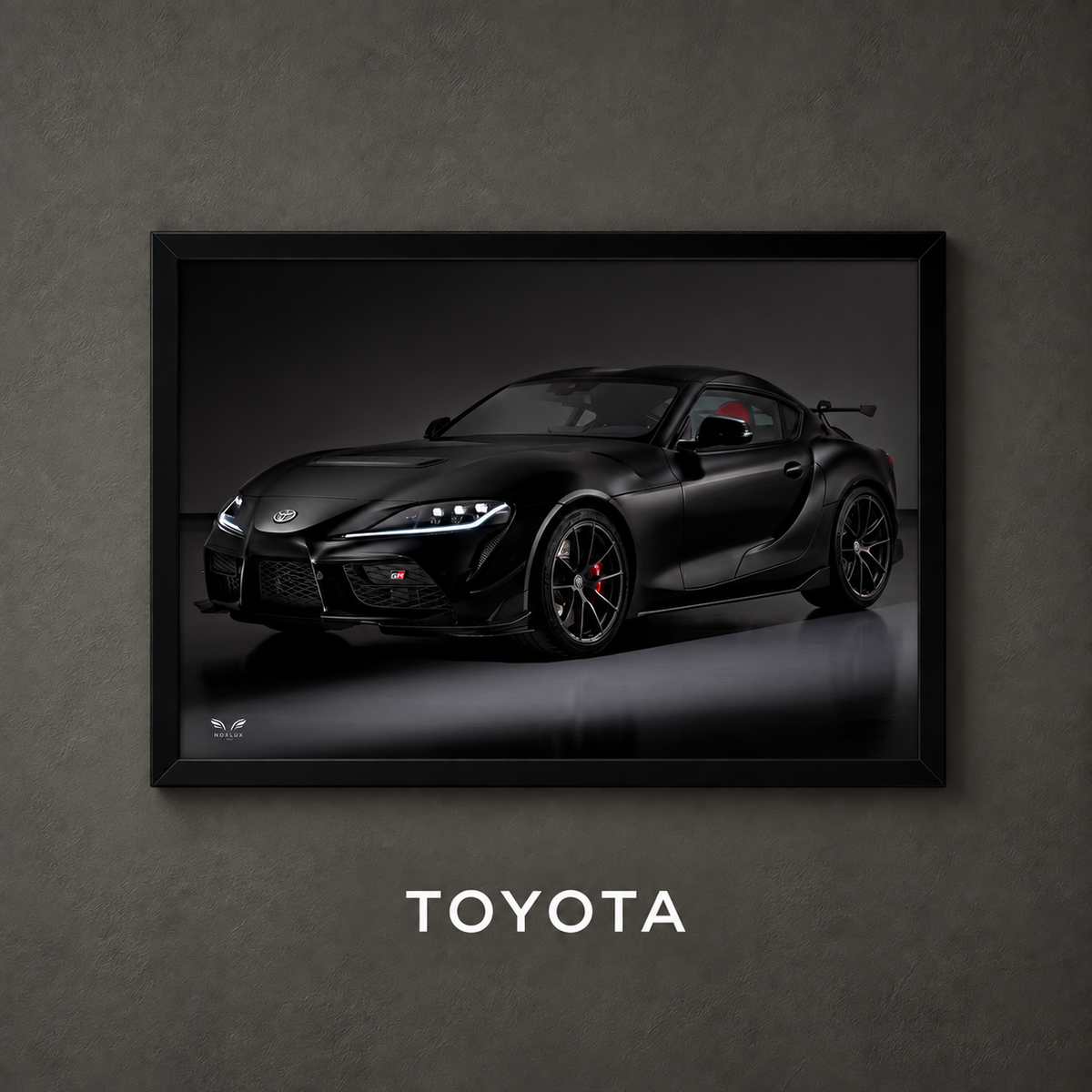 Framed Toyota car poster on a charcoal wall with collection label